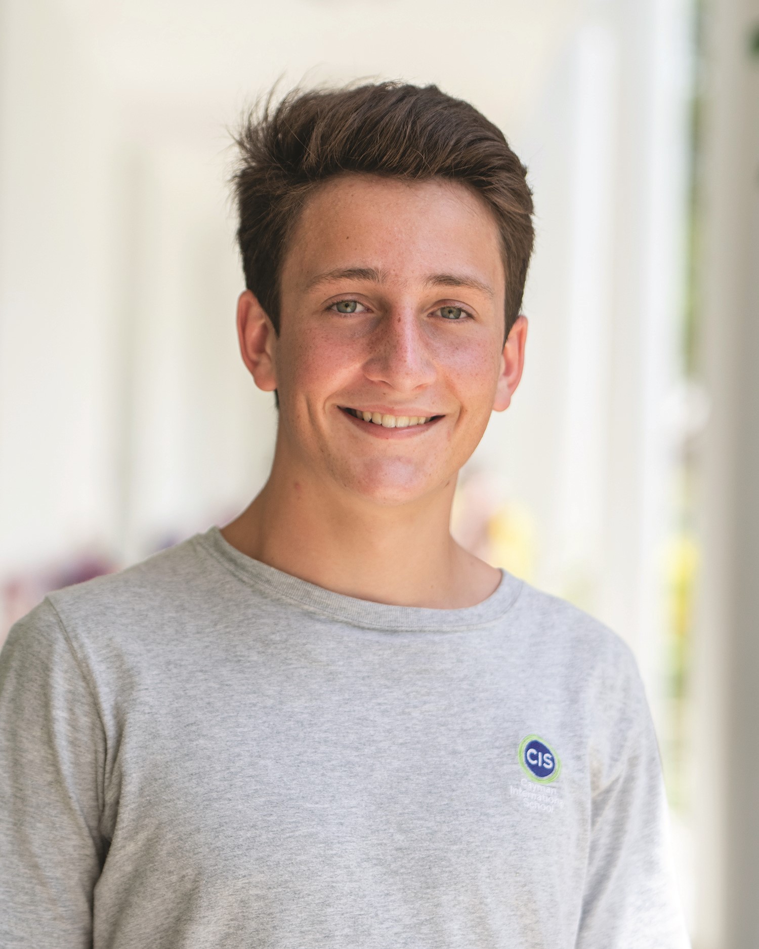 caucasian pre-teen male with brown hair smiles at the camera