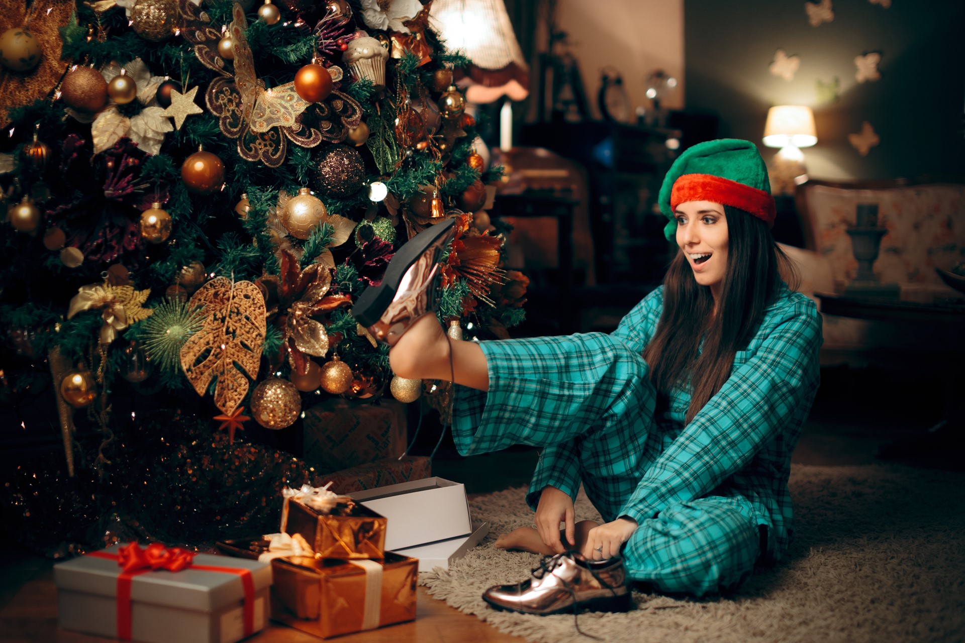 woman trying on shoes under Christmas tree