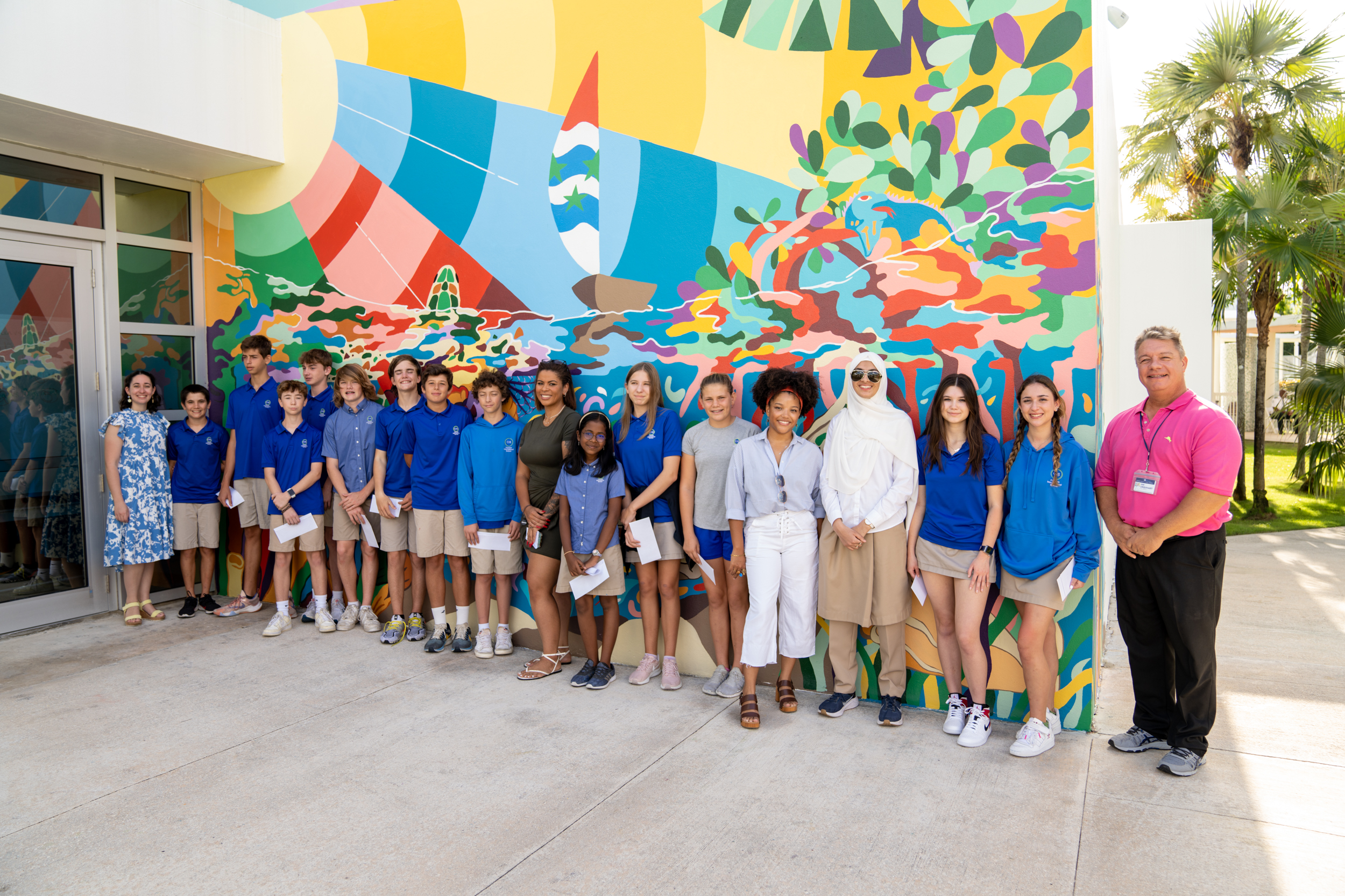 Students stand in front of mural