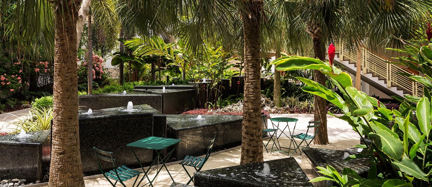 courtyard-with-palm-trees-fountains-and-a-blue-table-and-chair