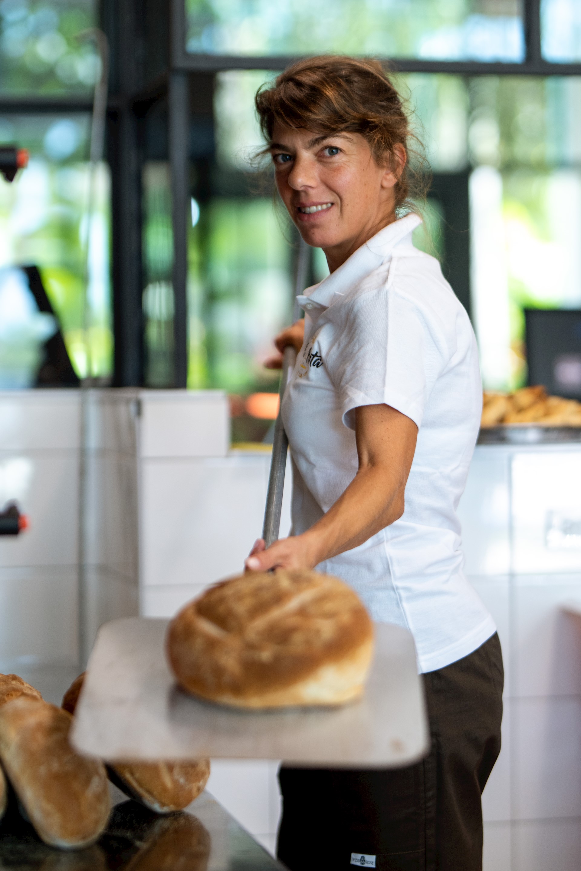 woman-holding-showing-fresh-bread-out-of-the-oven