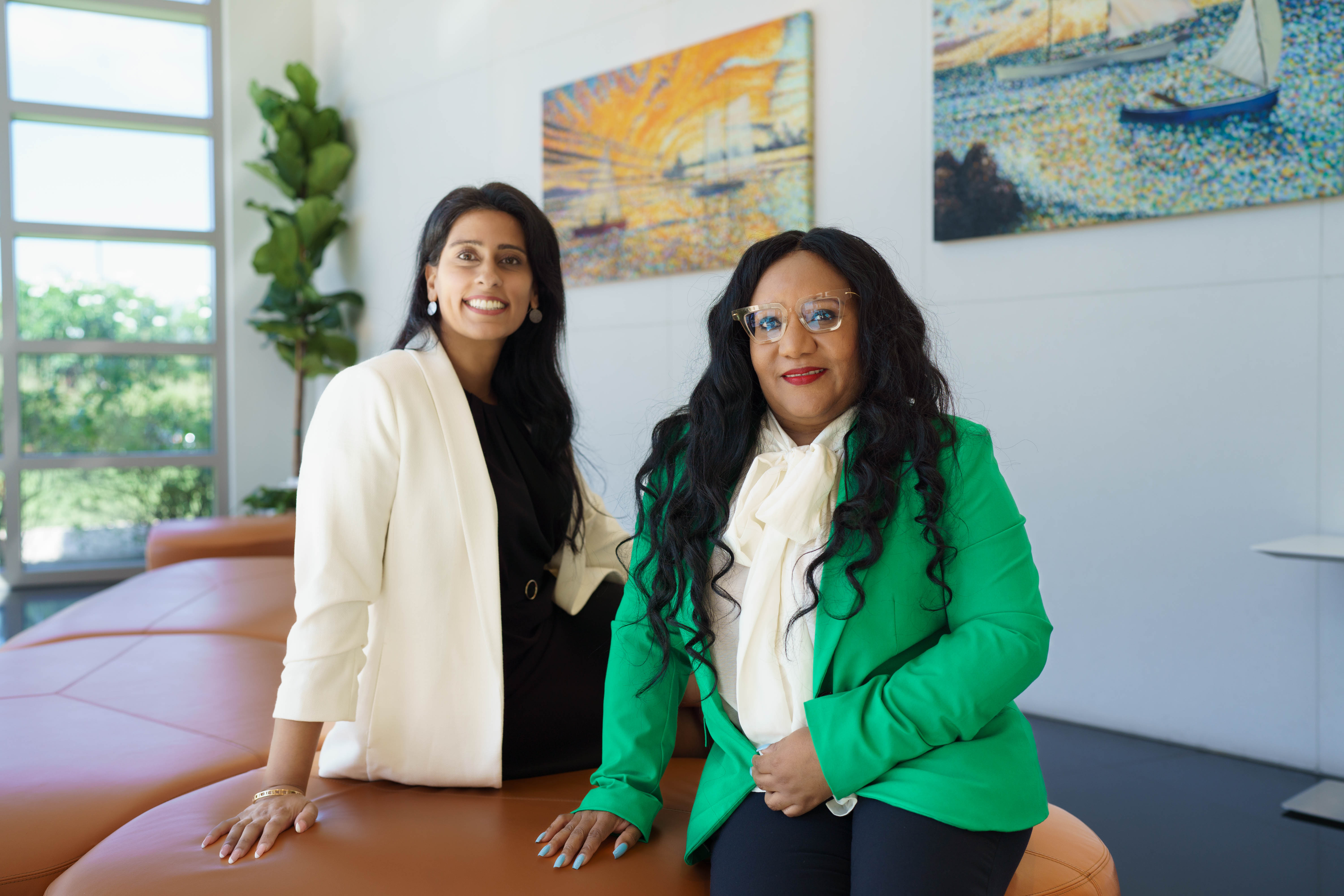 Two woman posing for the camera in office