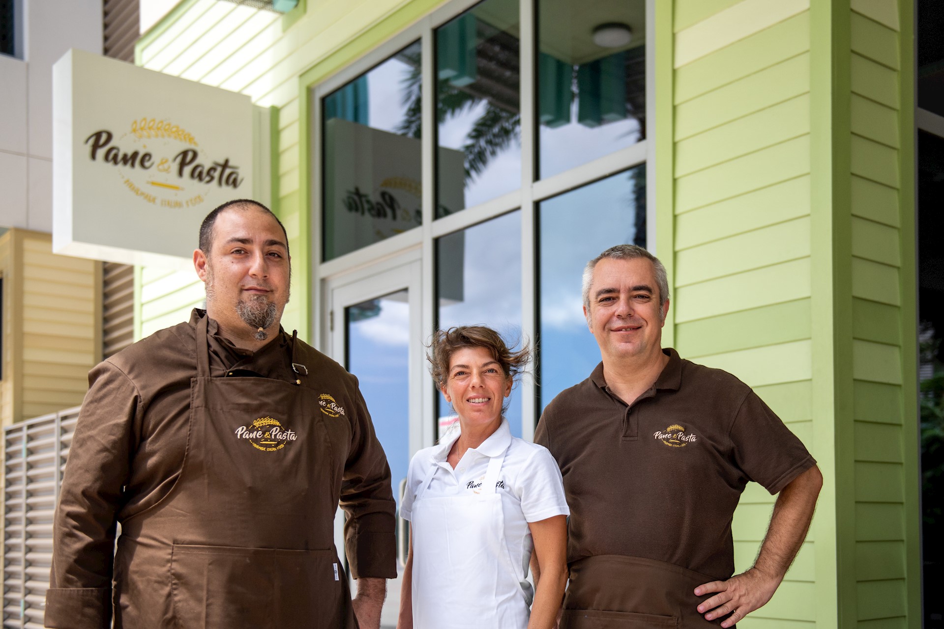 pane-and-pasta-team-smiling-in-front-of-camana-bay-restaurant