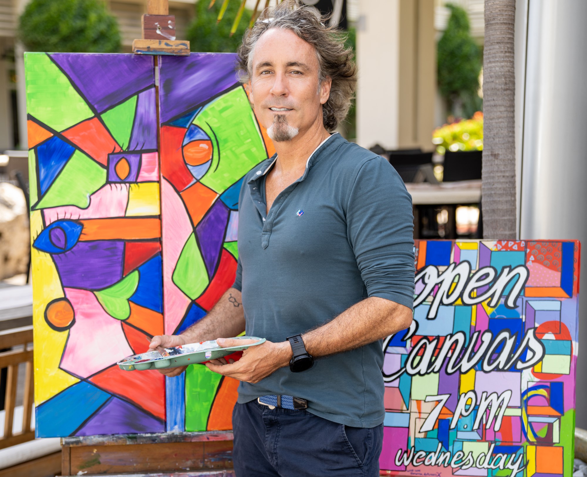 Artist stands in front of painting