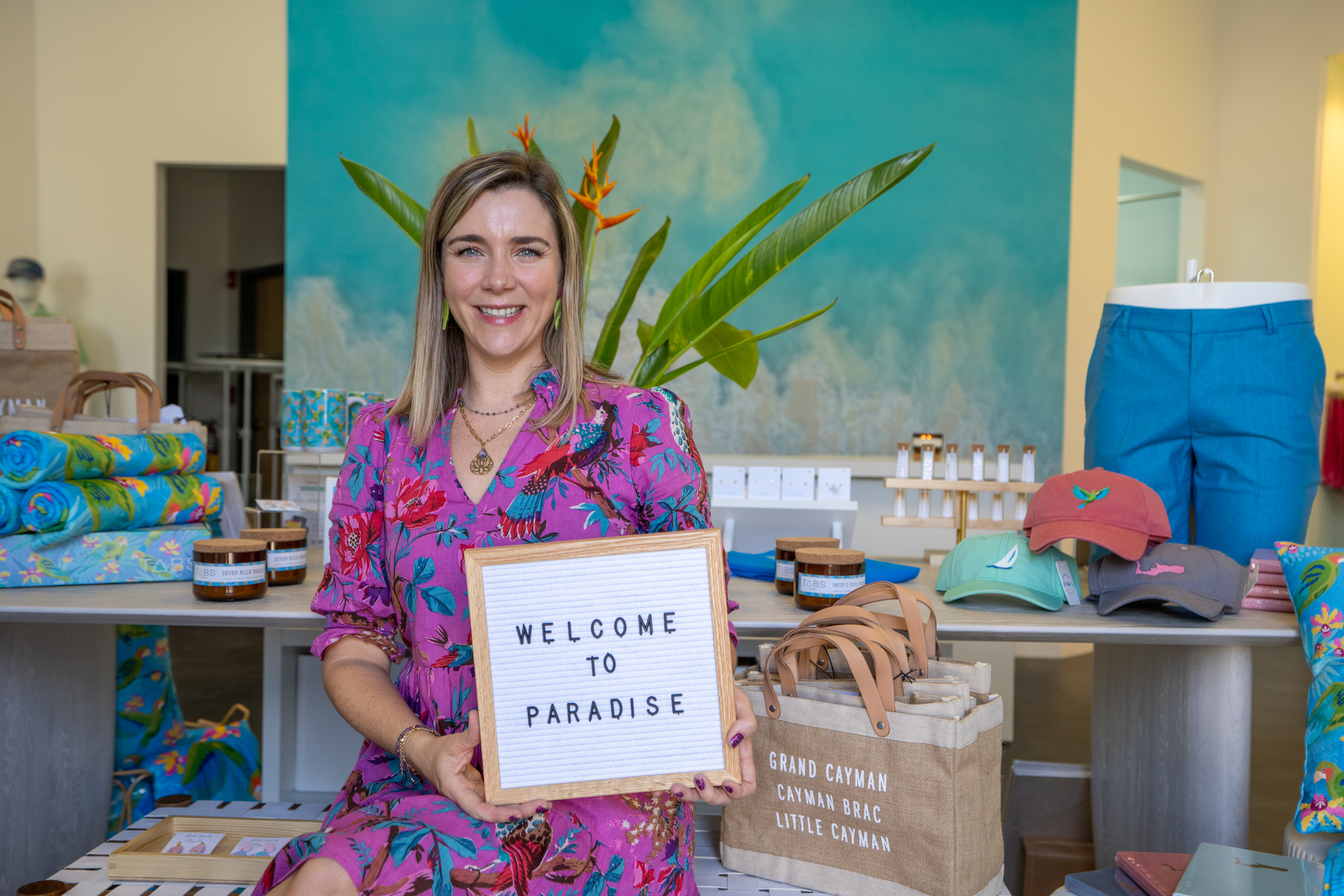 Woman holding sign that says Welcome to paradise