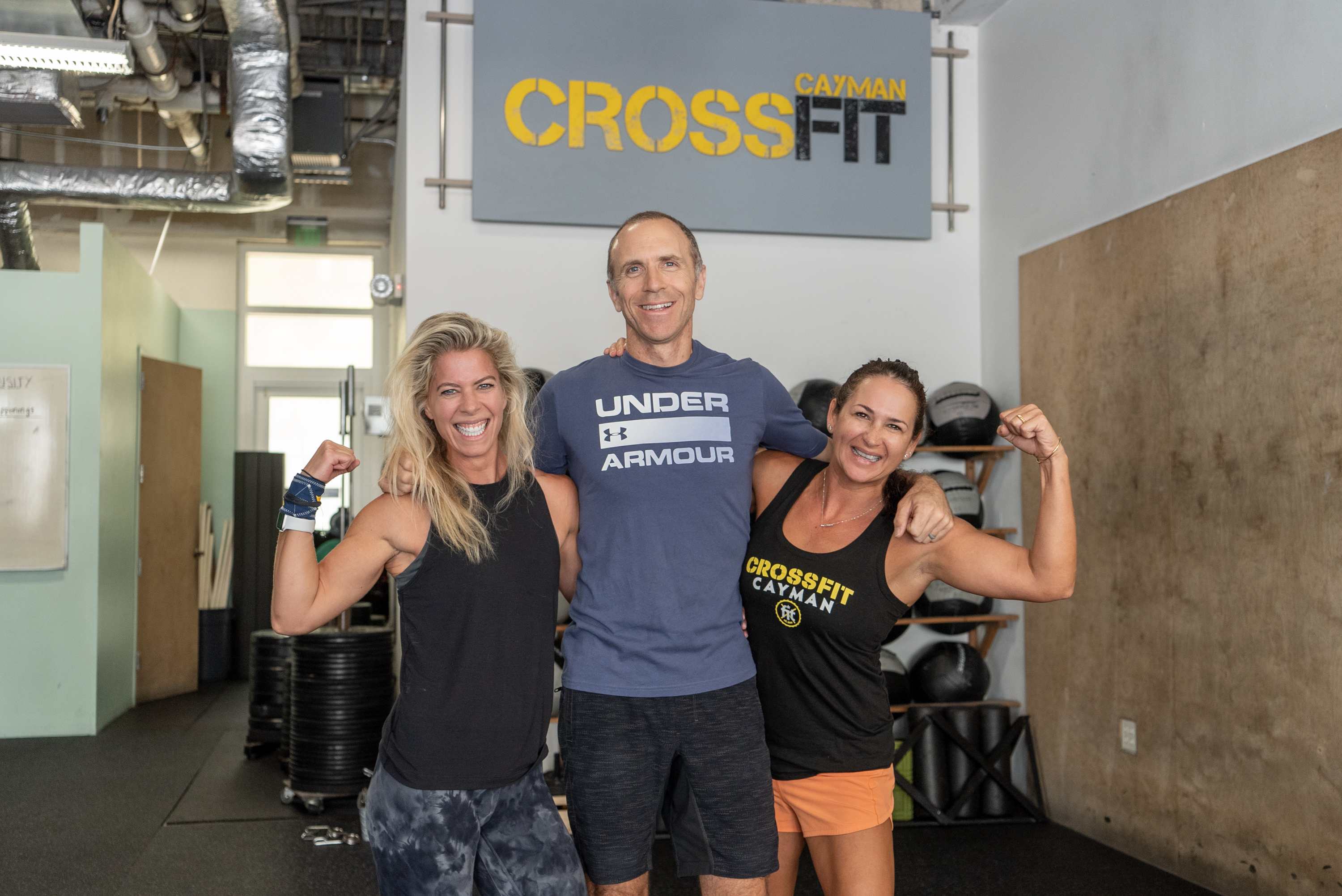 A man and two women standing in gym