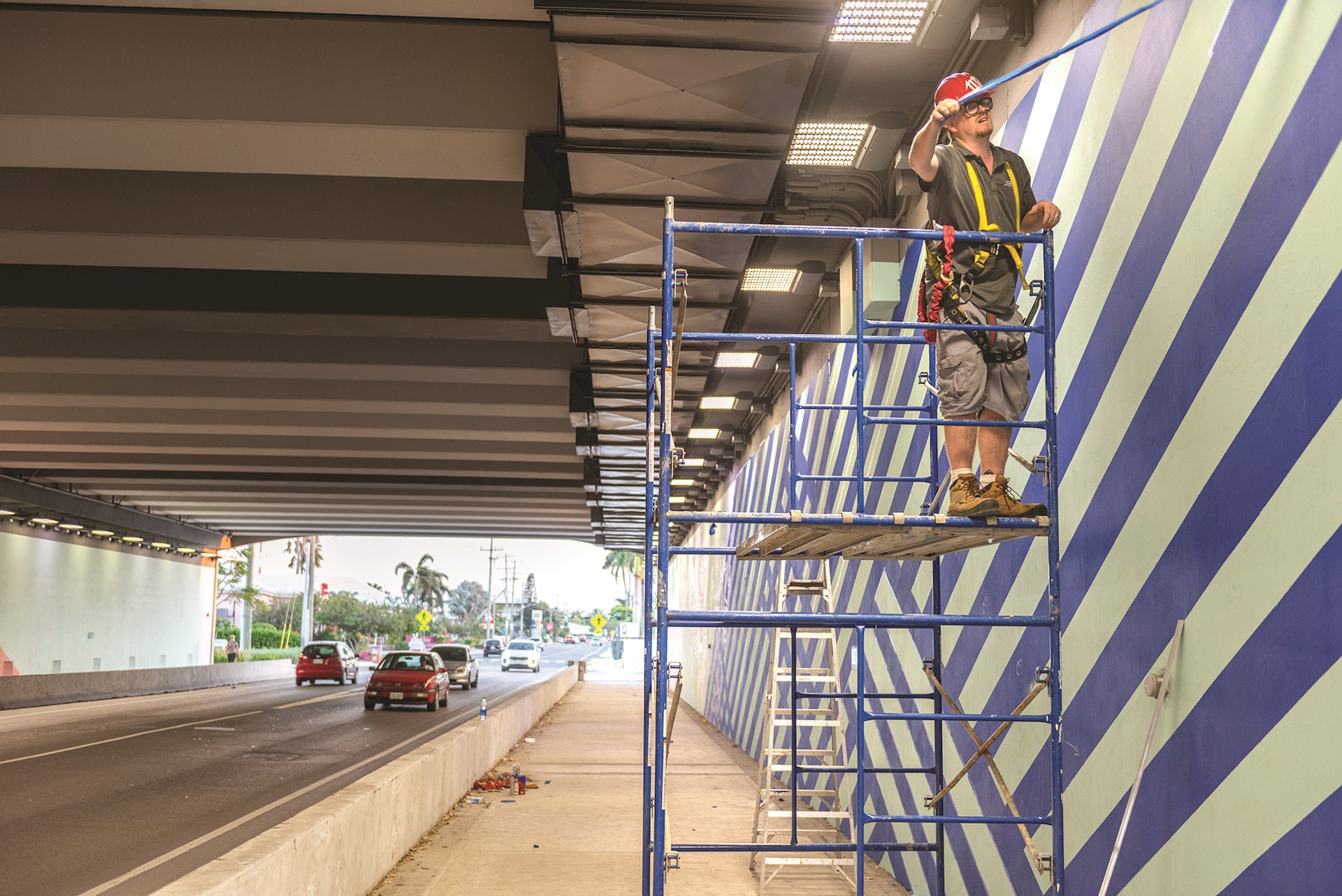 artist painting wall standing on scaffolding