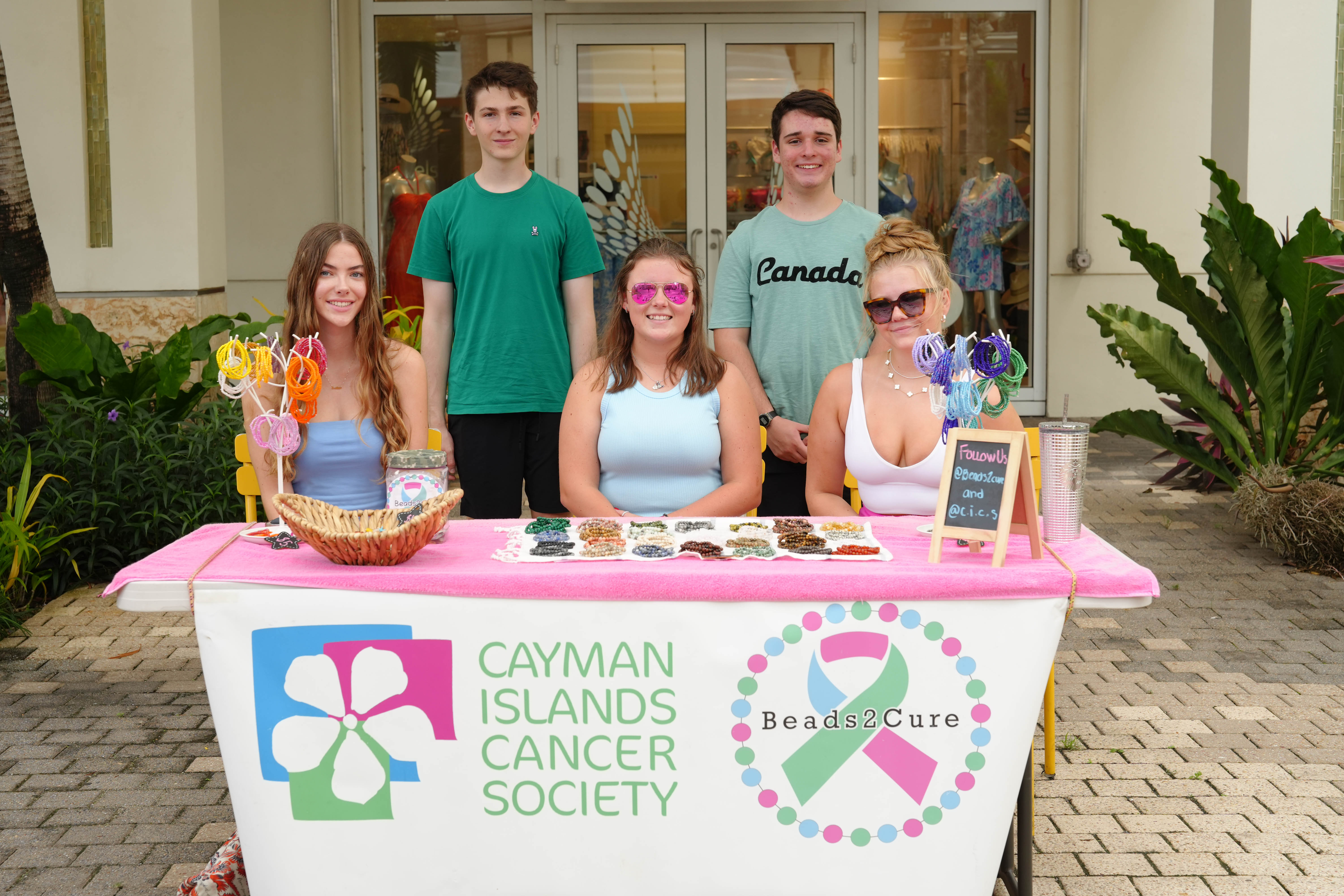 Teens sitting at cancer foundation stall