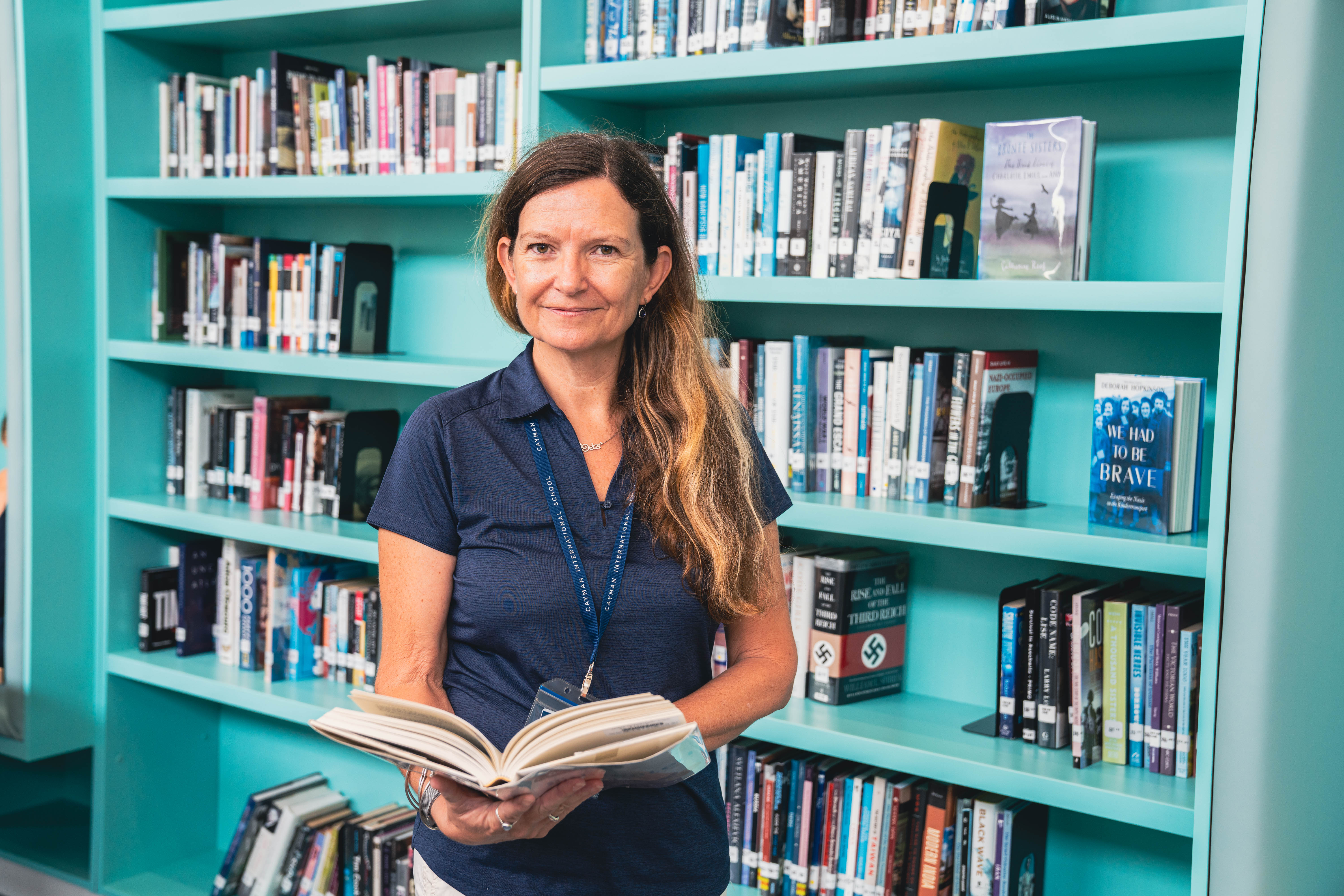 Woman smiling in front of bookcase