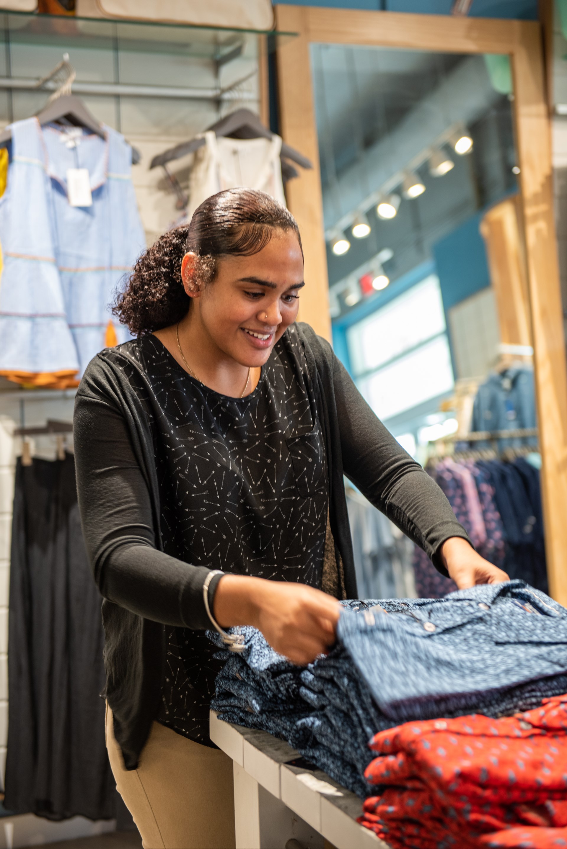 Woman organises clothing in a store