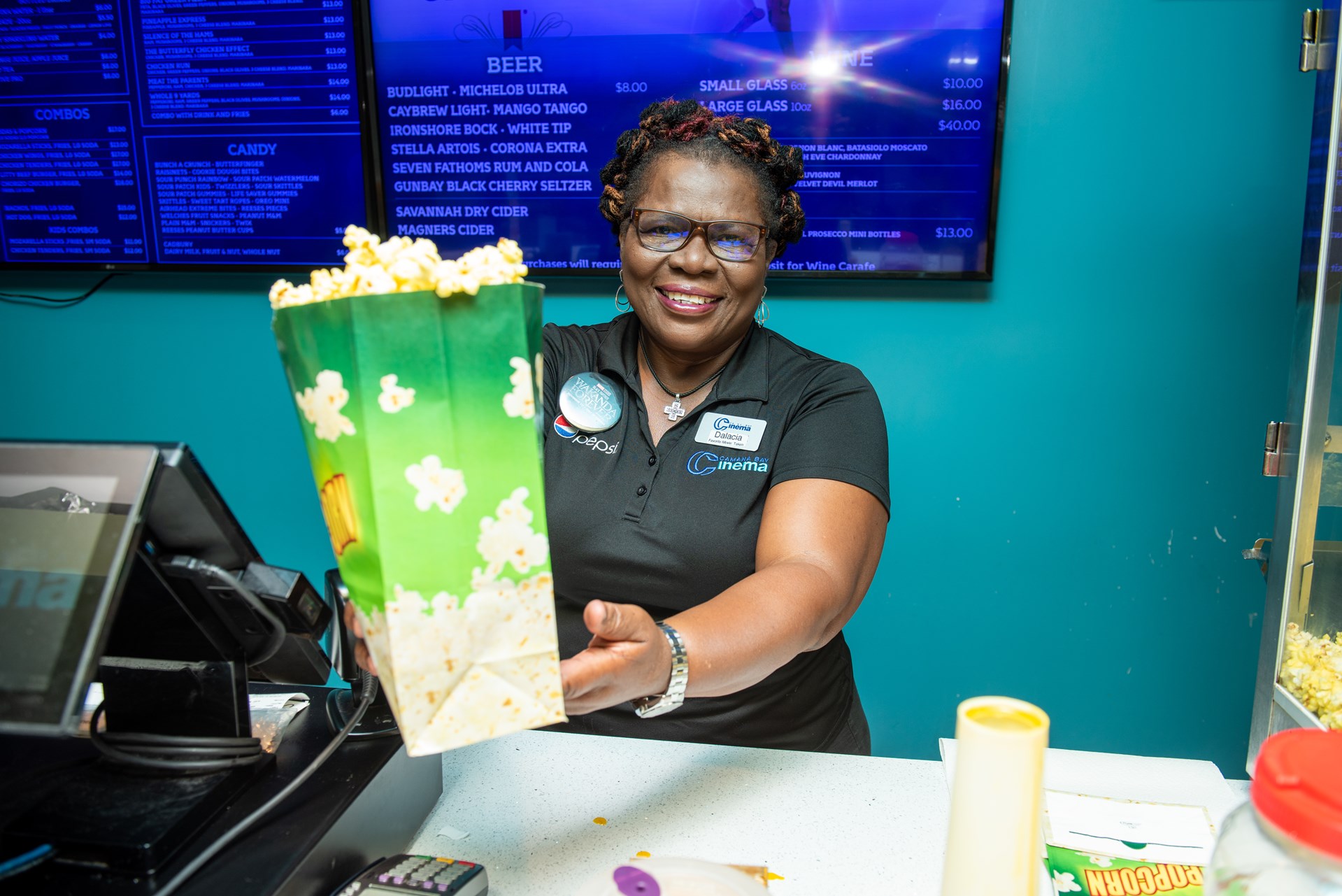 Black female smiles and holds a bag of popcorn