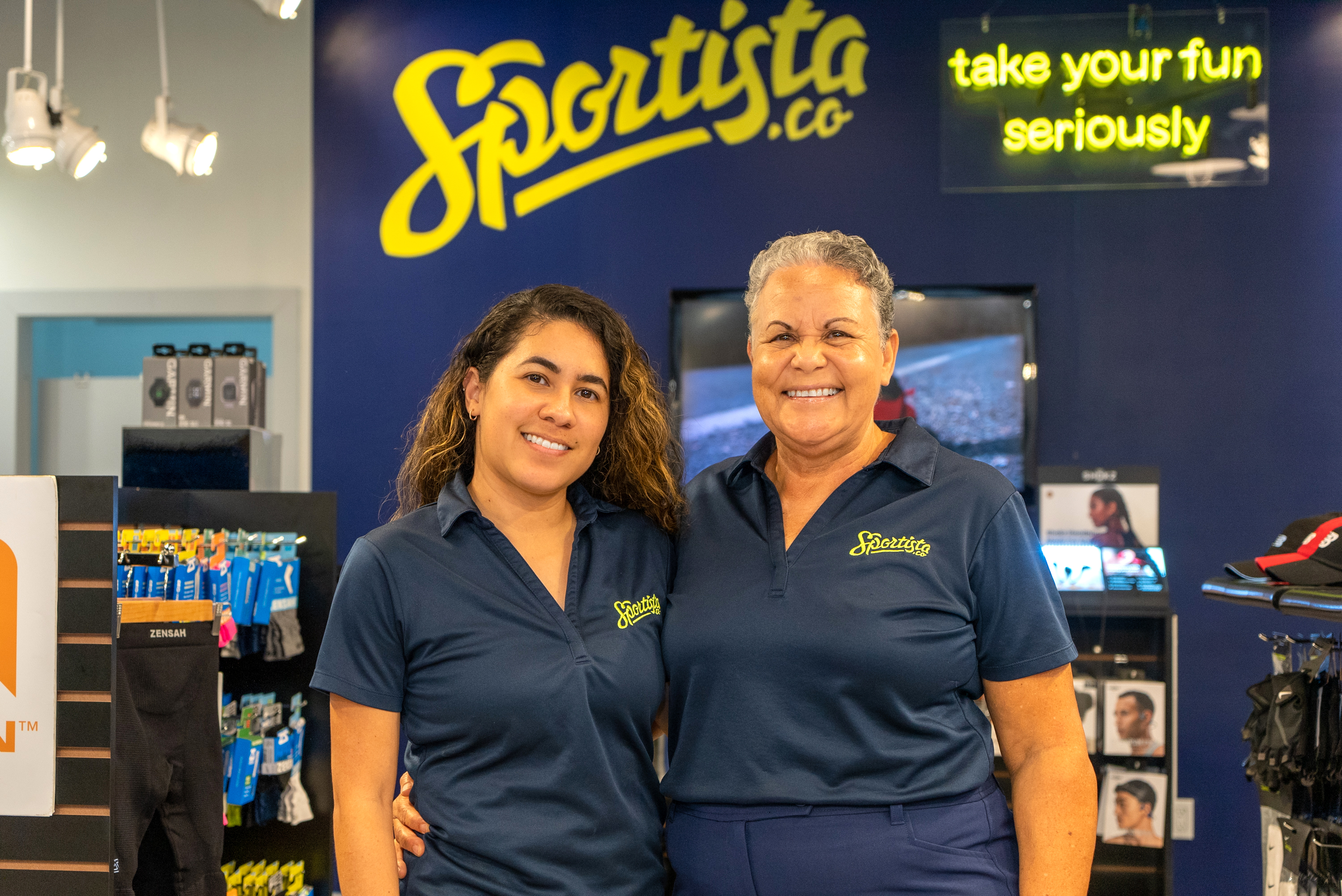 mom and daughter stand in their shop