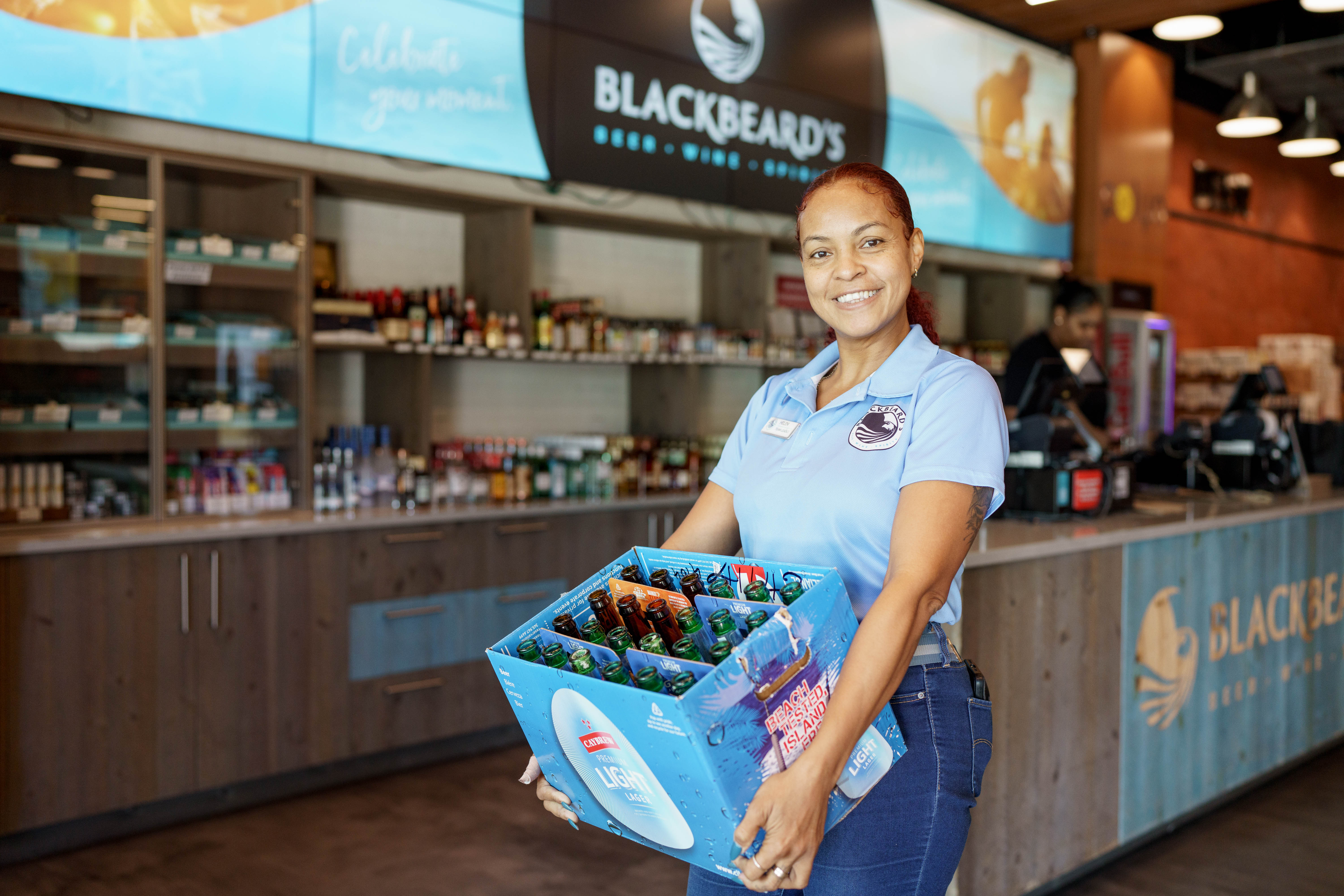 Woman holding a box of empty beer bottles